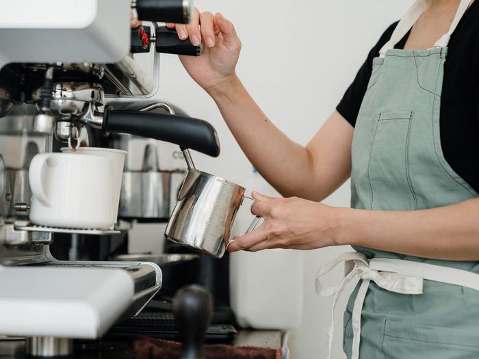 Barista steaming milk at an espresso machine