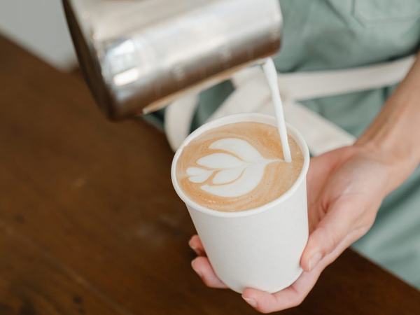 Pouring latte art into a takeaway cup